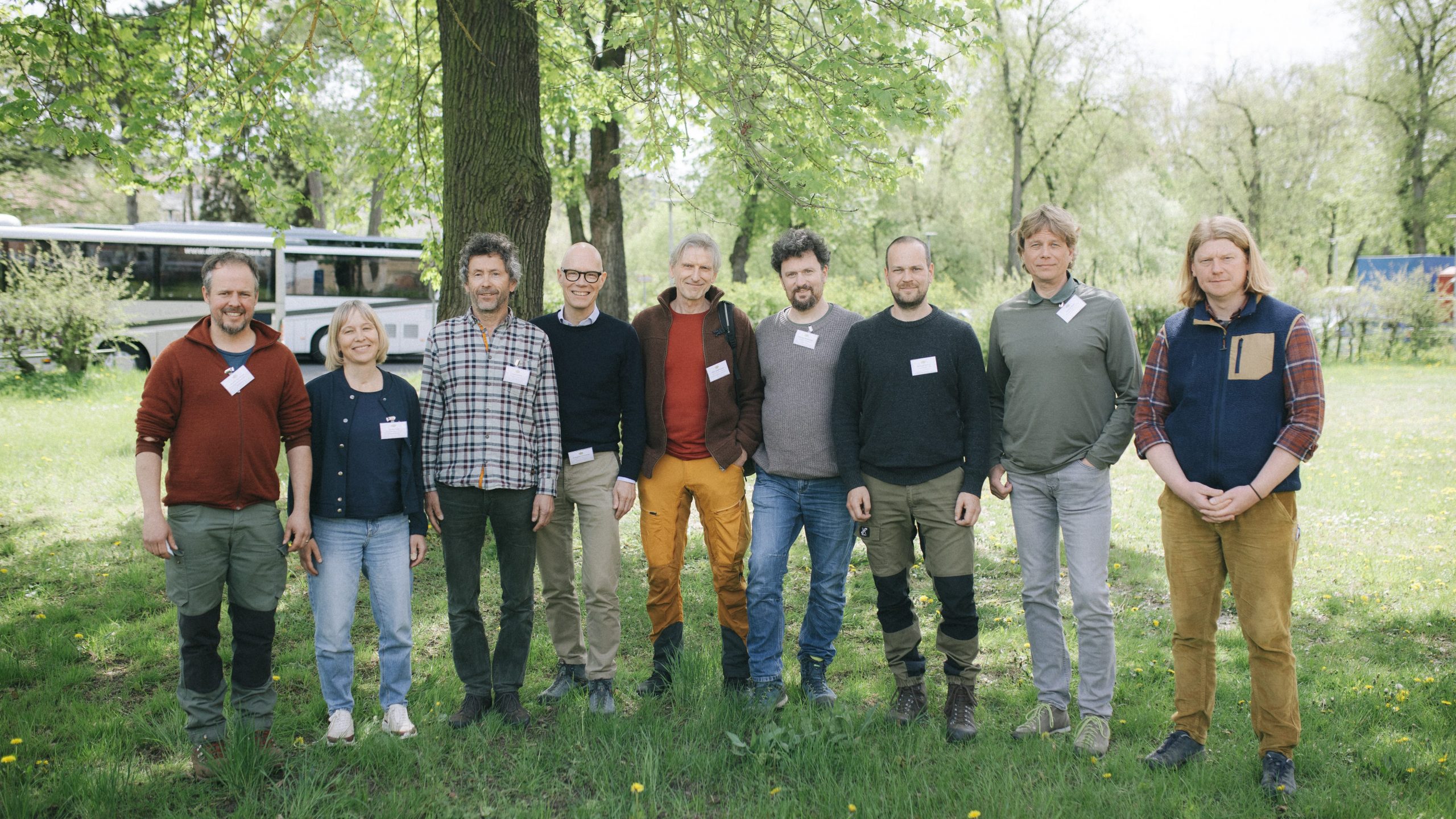 Die Praxispartner der Wald-Allianz stehen auf eine Wiese unter einem Baum
